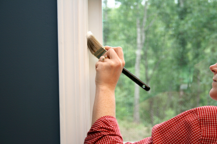 Shown:  Woman painting wood trim in a home.